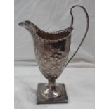 A 15cm high silver pedestal cream jug by Hester Bateman, with embossed floral and swag