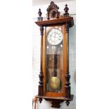 An antique mahogany and mixed wood cased Vienna regulator wall timepiece with visible pendulum and