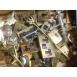 A box containing a quantity of metal items, including brass fronted light switches, taps etc.