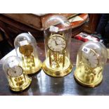 Four anniversary clocks comprising two Kundo, Bentima and Herr examples, all with ball pendulums and