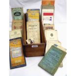 A wooden box containing a collection of pre-war and other vintage linen backed and other folding