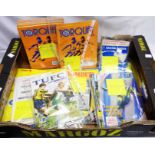 A box containing a collection of vintage and later Torquay United AFC football programmes from the
