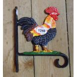A modern painted cast iron hanging basket wall bracket with cockerel decoration