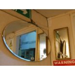 A vintage frameless bevelled oval wall mirror with cast metal bow pediment - sold with a small