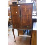 A 61cm vintage reproduction mahogany and cross banded serpentine front writing cabinet with