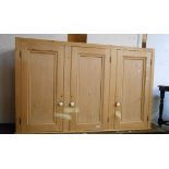 A 1.64m Victorian style pine three door cupboard with shelves enclosed by panelled doors