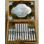 An early 20th Century walnut cased part set of silver plated knives and forks with decorative