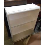 A small modern white painted three shelf open bookcase