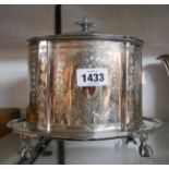 An old ornate silver plated biscuit barrel with hinged lid and screw-on integral tray base, set on