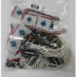 A bag containing a quantity of African beaded necklaces