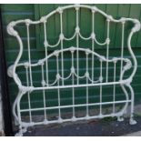 A modern cast iron bed with decorative scrolling and white painted finish