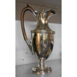 A silver plated wine ewer with hinged lid, wooden handles and loaded base