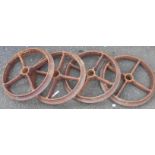 A set of four old iron wheels from a disc harrow