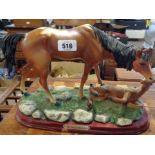 A vintage cast brass figurine depicting a horse leaping over a gate - sold with a resin figure of