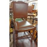 A set of eight oak framed panel back dining chairs with studded brown leather upholstery and drop-in