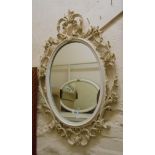 An ornate reproduction Rococo style wall mirror with white and parcel gilt finish