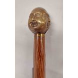 A modern walking stick with cast brass oriental style four face handle