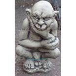 A cast concrete garden statue of a gargoyle in thoughtful pose