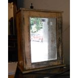 A small mixed wood bathroom cabinet with mirror panel door