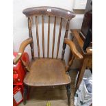 An antique stained mixed wood elbow chair with elm armrests and moulded solid elm seat, set on