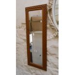 A reproduction stained wood framed narrow oblong wall mirror with rope twist border