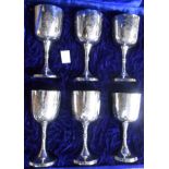 An upholstered cased set of six Indian silver plated goblets with engraved decoration