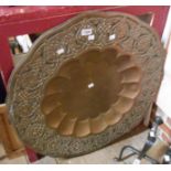 A large Eastern brass tray with central lobed well and embossed border
