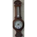 A late Victorian carved oak framed banjo barometer/thermometer with printed ceramic dial and aneroid