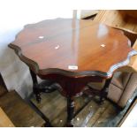 A 75cm Edwardian stained walnut two tier occasional table with shaped surfaces, set on reeded