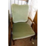 A vintage mahogany framed panel back elbow chair with frosted green velour upholstery, set on