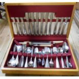 A vintage oak canteen containing Oneida and other steel cutlery