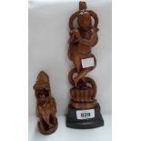 An Indian carved wooden figure depicting a deity with entwined cobra - sold with a similar