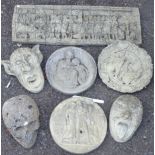 Seven concrete garden ornaments including wall masks, plaques, etc.