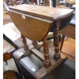 A small polished oak swivel-top table, set on turned supports