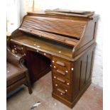 A 1.2m vintage oak roll-top desk with damaged tambour enclosing a part fitted interior over eight