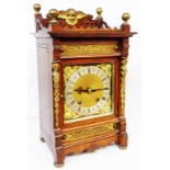 An early 20th Century brass mounted oak cased mantel clock with decorative spandrels and silvered