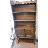 A 69cm early 20th Century oak dresser with three open plate shelves over a pair of decorative