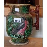 A 19th Century Majolica pottery jug with moulded bird of prey decoration and coloured lead