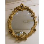 A vintage ornate gilt plaster framed Rococo style wall mirror with shaped plate