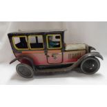 An old tin plate model taxi with clockwork movement