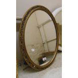 A vintage gilt framed oval mirror with adapted easel back