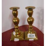 A pair of antique brass candlesticks