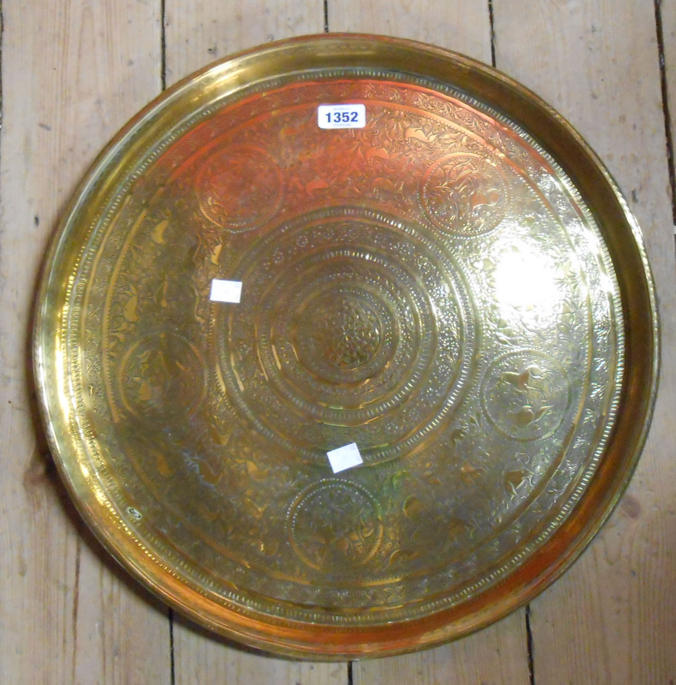 An embossed and chased Eastern brass tray depicting animals and figures