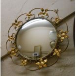 A vintage decorative gilt metal framed convex wall mirror with flowerhead decoration