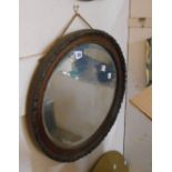 An early 20th Century ornate wood grained framed bevelled oval wall mirror - slight loss to