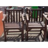 A pair of painted wood garden chairs with slatted backs and seats