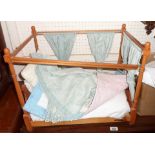 A wooden four poster doll's bed