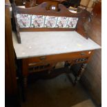 A 90cm Edwardian stained walnut and mixed wood washstand with tile set splash back and frieze