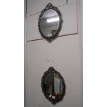 A pair of vintage decorative cast metal framed oval wall mirrors with brassed finish in the