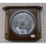 A vintage oak framed wall barometer/thermometer with storm glass and aneroid works